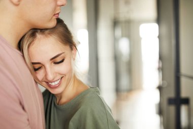 Ev sırasında kocasının göğüs tarafından eğilerek dişli gülümseme ile Pretty genç karısı dinlenmek