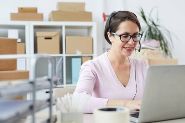 Çevrimiçi müşterilere danışmanlık yaparken kulaklık mikrofonu konuşan mutlu yardım masası operatörü