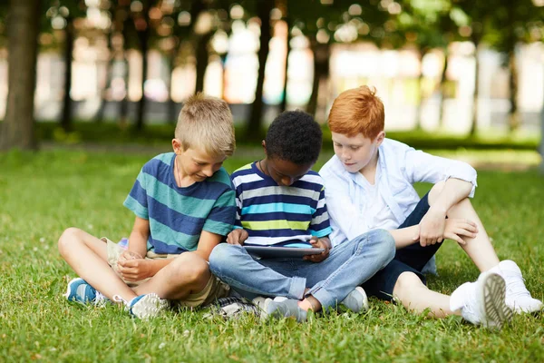 Трое Улыбающихся Школьных Друзей Сидят Парке Траве Вместе Играют Новую — стоковое фото
