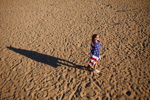 Amerikan Bayrağına Sarılı Güneş Gözlüklü Rüya Gibi Kızın Yukarıda Kumda — Stok fotoğraf