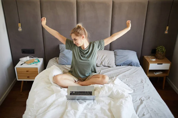 Jonge Casual Vrouw Stretching Haar Armen Terwijl Zittend Bed Voor — Stockfoto