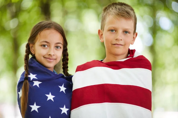 Retrato Contenido Niños Estadounidenses Envueltos Bandera Estadounidense Pie Parque Verano —  Fotos de Stock