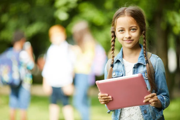 Leende Teenage Schoolgirl Med Flätat Hår Och Rosa Tablet Stående — Stockfoto