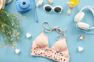 Tatil şeyler ile mavi arka plan üzerinde kayışları ile şık mayo üst görünümü yukarıda