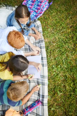 Dört genç okul arkadaşı okulda derslerden sonra çimenlerin üzerinde yatan parkta birlikte Matematik ödevi yapıyor