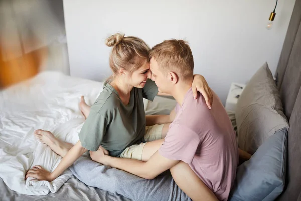Kucaklaşmada Birbirlerinin Önünde Yatakta Oturan Shirt Mutlu Genç Eşler — Stok fotoğraf