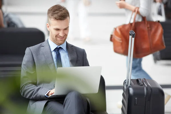 Joven Vendedor Sonriente Con Rastrojo Usando Traje Gris Sentado Aeropuerto — Foto de Stock