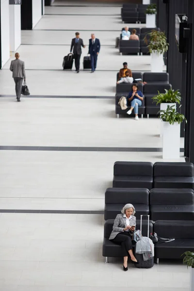 在现代机场候机室中坐和走的商务人士的上方视图 — 图库照片