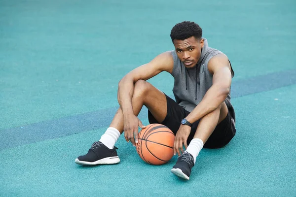 Retrato Completo Del Apuesto Deportista Africano Sentado Suelo Cancha Baloncesto — Foto de Stock