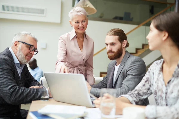 Ofiste çalışanları ile toplantı ve dizüstü ekran işaret modern üst düzey iş kadını lider Portresi, kopya alanı