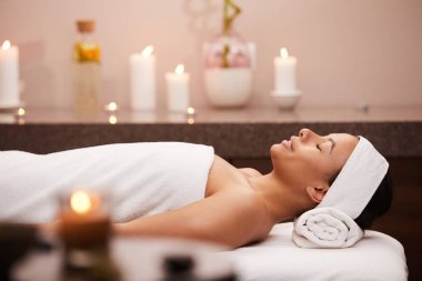 Spa masaj masasında yatarken mutlu bir şekilde gülümseyen güzel karışık ırk kadın Yan görünümü portre, kopya alanı