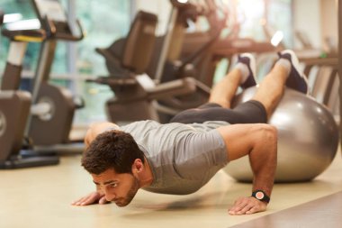 Yakışıklı Orta Doğu lu adamın tam uzunlukta portresi spor salonunda egzersiz sırasında fitness topu üzerinde push up yapıyor, kopya alanı