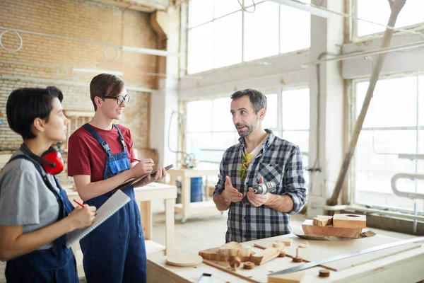 Atölyede genç çıraklar öğretim olgun marangoz Portresi, kopya alanı