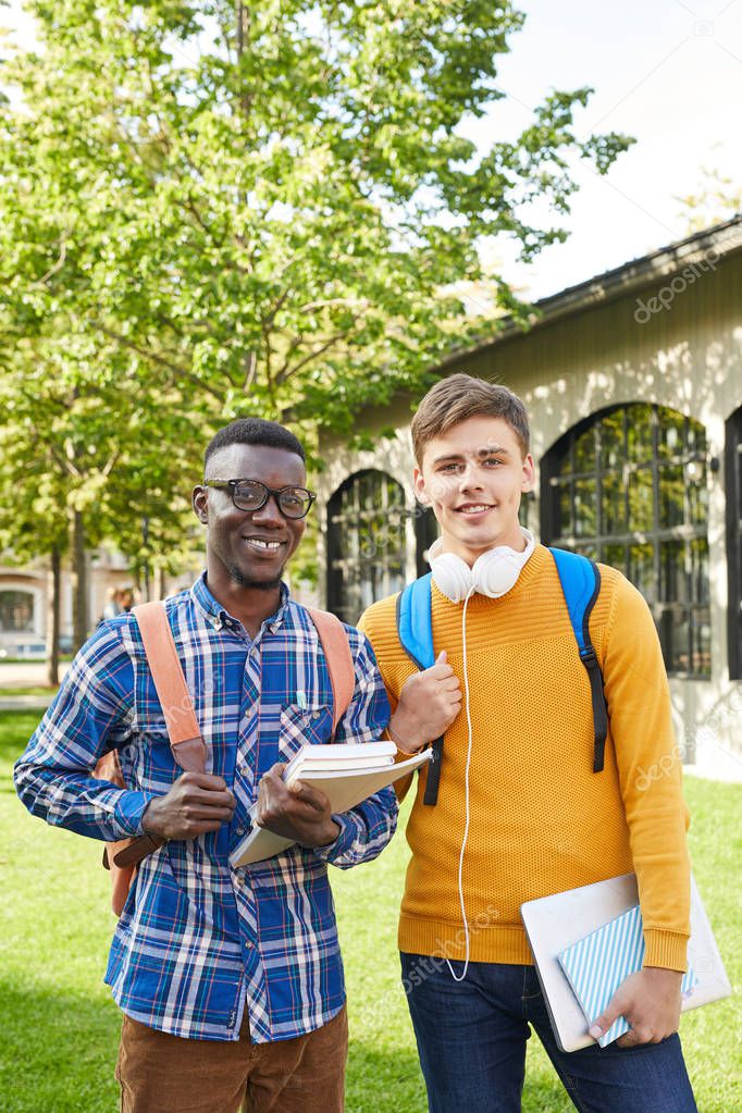 Waist up portrait of two college students posing outdoors in campus, copy space