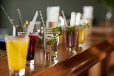 Bar tezgahında renkli içecekler, ferahlatıcı kokteyller ve mojito bardakları, kopyalama alanı.