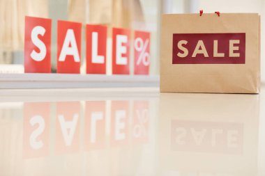 Alışveriş çantasının arkaplan resmi kırmızı satılık işareti olan pencere ekranına karşı duruyor, boşluğu kopyala