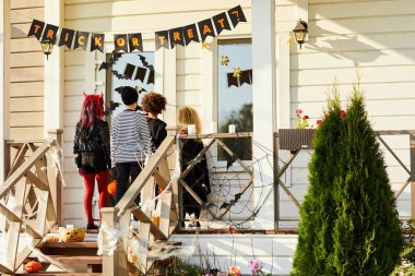 Çocukların Cadılar Bayramı 'nda şeker toplamaya çıkmaları, çocukların verandada durup dekore edilmiş evlerin kapılarını çalmaları, fotokopi çekmeleri.