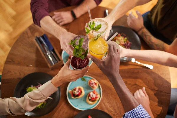 冷たいさわやかな飲み物を楽しむカフェでテーブルに座っている間にガラスをクリックしている友人の高い角度の閉鎖 コピースペース — ストック写真