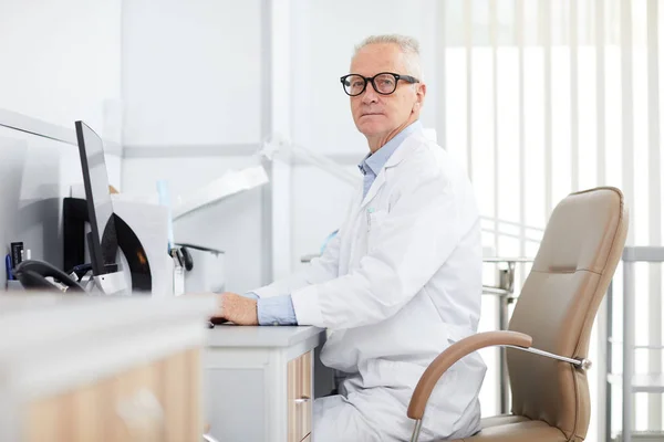 Portrait Senior Doctor Sitting Desk Looking Camera While Posing Office — Stock fotografie