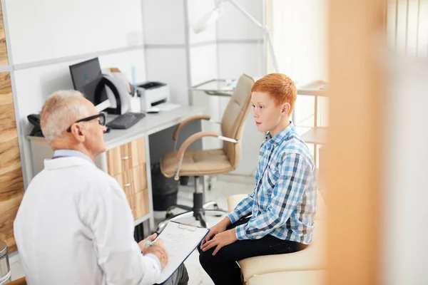 Modern Çocuk Sağlığı Kliniğinde Danışmanlık Yaparken Kıdemli Doktorla Konuşan Genç — Stok fotoğraf