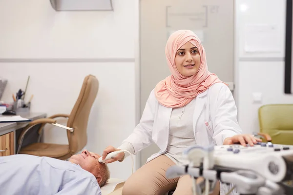 Portret Młodej Arabki Pracującej Jako Lekarz Wykonującej Badanie Ultrasonograficzne Starszego — Zdjęcie stockowe
