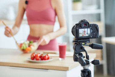 Yemek videosu kaydeden, kamera ekranına odaklanan, uzayı kopyalayan, tanımlanamayan fit kadını kapat