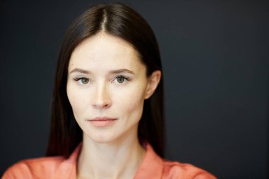 Kendine güvenen beyaz tenli esmerin yatay yakın portresi. Kameraya bakıyor, uzayı kopyalıyor.