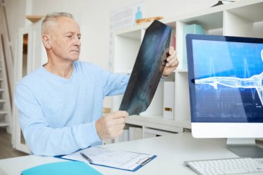 Modern klinikteki danışma sırasında X-ray görüntüsü tutan yaşlı adamın portresi, boşluğu kopyala