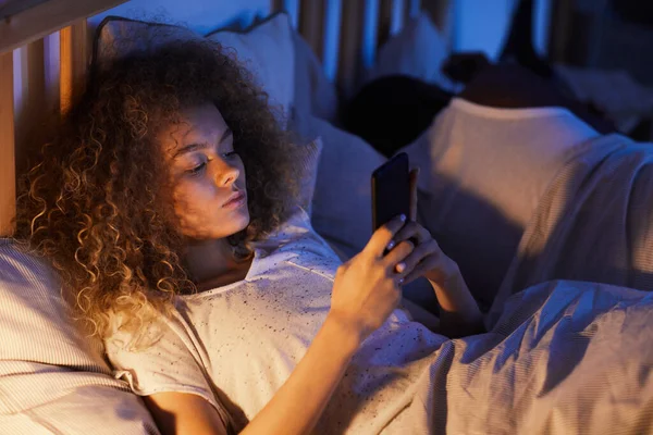 High Angle Portrait Curly Haired Young Woman Using Smartphone Bed — Stock Photo, Image