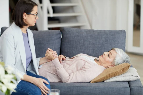 Sidovy Porträtt Äldre Kvinna Ligger Soffan Med Ung Dotter Håller — Stockfoto