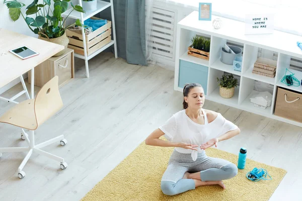 Modern genç bayana geniş açılı bakış açısı evde meditasyon yaparken nefes egzersizlerinden zevk alıyor, boşluğu kopyalıyor.