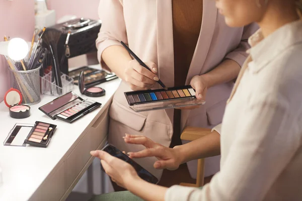 Close Female Make Artist Holding Eyeshadow Palette While Doing Clients — Stock Photo, Image