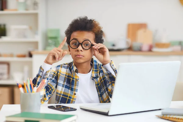 自宅で勉強しながらノートパソコンを使って大きな眼鏡をかけてかわいいアフリカの少年の肖像 遠隔教育の概念 コピースペース — ストック写真