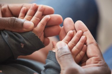 Babalığın tadını çıkarırken, minik elleri olan, tanınmayan Afro-Amerikan bir adamın yakın çekimi.