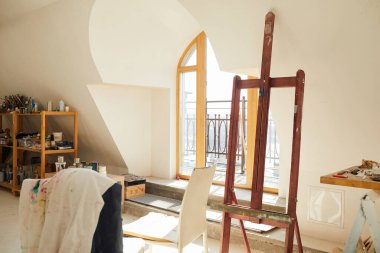 Güneş ışığıyla aydınlatılan tavan arasındaki ilham verici sanat stüdyosunun arkaplan görüntüsü, eski ahşap sehpaya odaklan, boşluğu kopyala
