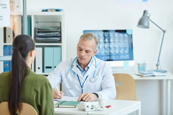 Portrait Médecin Homme Mature Écrivant Sur Presse Papiers Assis Bureau — Photo