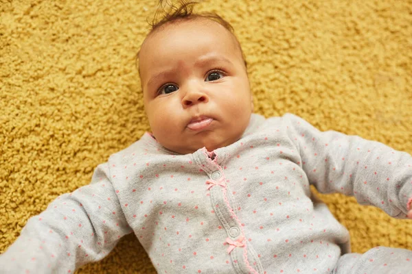 Beyaz Tüylü Sarı Halıda Yatarken Kameraya Bakan Sevimli Melez Bebek — Stok fotoğraf