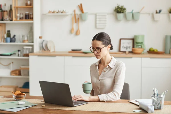 居心地の良い自宅のオフィスでノートパソコンを使用しながらエレガントなビジネス女性がコーヒーを飲むの肖像画 スペースをコピー — ストック写真