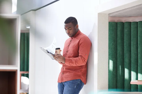 Retrato Joven Afroamericano Leyendo Documentos Sosteniendo Taza Café Mientras Está — Foto de Stock