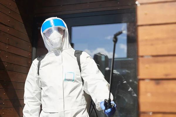 男工在消毒过程中穿着防护服 在室外向相机喷洒化学药品 复制空间的倒挂肖像 — 图库照片