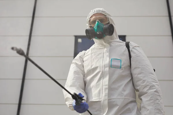 一名穿着防护服和在室外消毒或清洗时喷洒化学品的工人的低角度肖像 复制空间 — 图库照片