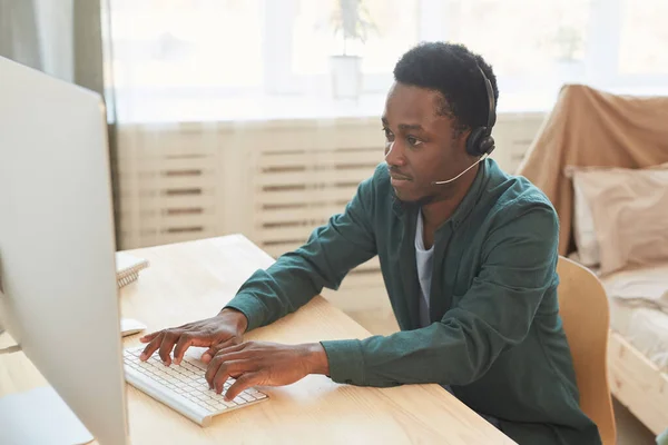 Evde Çalışırken Kulaklık Takan Bilgisayar Kullanan Afro Amerikan Genç Adamın — Stok fotoğraf