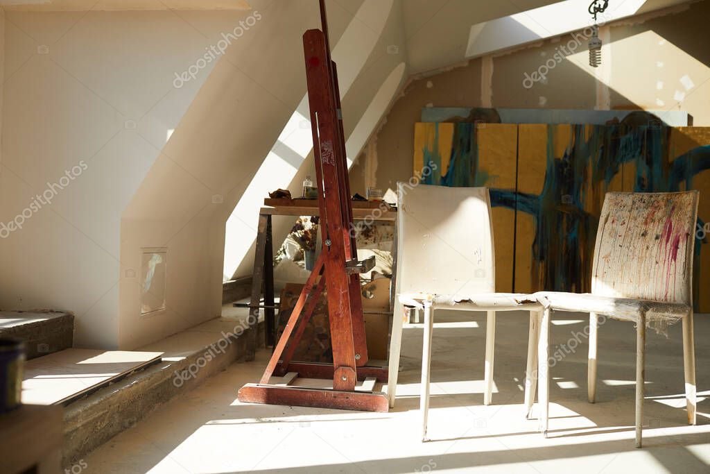 Background image of empty art studio in attic space, old chairs splattered with paint in foreground, copy space