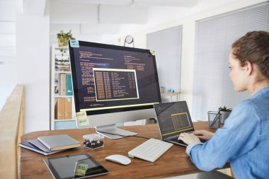 Bilgisayar ekranında siyah ve turuncu programlama kodlarıyla klavyede yazan kadın bilişim geliştiricisinin portresi ve çağdaş ofis içi dizüstü bilgisayarı, boşluk kopyala