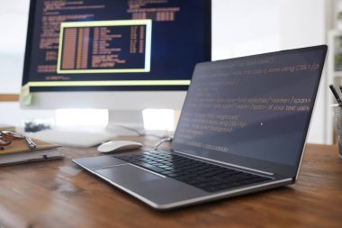 Bilgisayar ekranındaki siyah ve turuncu programlama kodunun arkaplan resmini kapat ve modern ofis içi dizüstü bilgisayarda, boşluğu kopyala