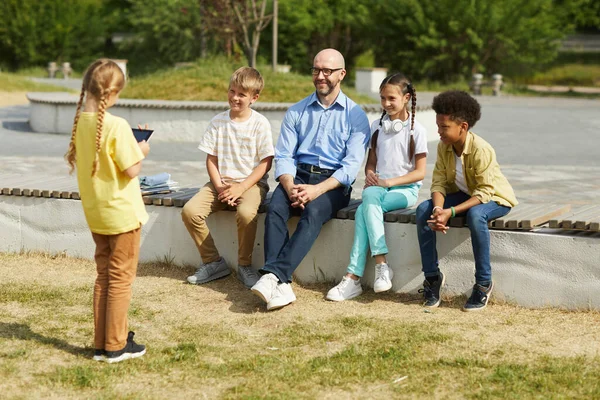 Full Length Portrait Smiling Male Teacher Listening Little Girl Giving — Stock Photo, Image