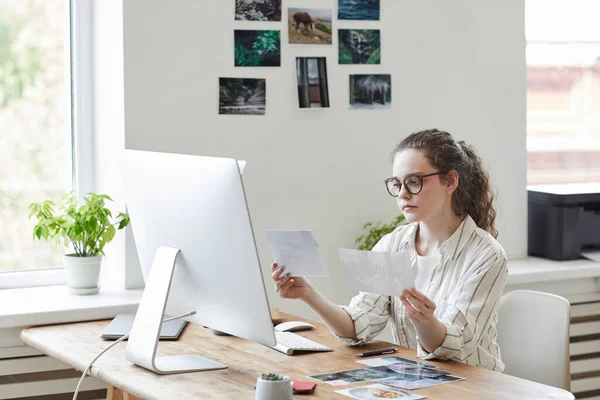 现代年轻女性在白领办公室电脑上工作时 在复印版面上对照片进行评论以供发表的肖像 — 图库照片
