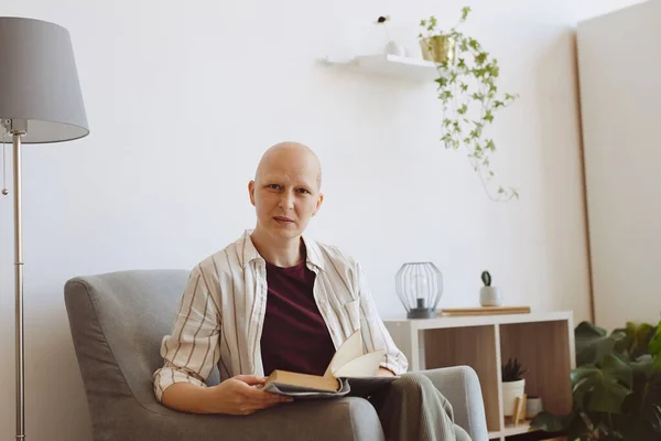 Portrait Bald Mature Woman Looking Camera While Reading Book Sitting — Stock Photo, Image