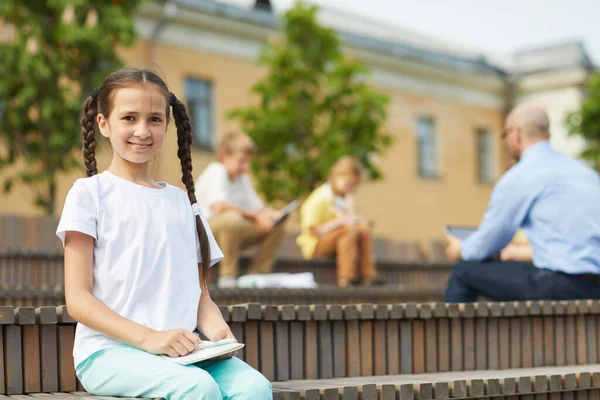 Porträtt Leende Tonåring Flicka Tittar Kameran Medan Sitter Bänken Utomhus — Stockfoto