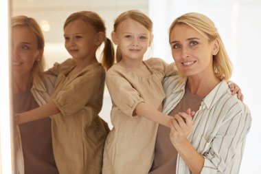 Mutlu yetişkin anne portresi gibi sıcacık. Küçük tatlı kızını kucağında tutuyor ve evde aynanın karşısında durup kameraya gülümsüyor. Uzayı kopyalıyor.